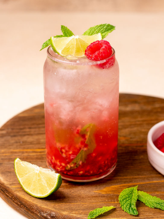 Raspberry nojito with lime wedge, mint spring, and raspberry as a garnish.