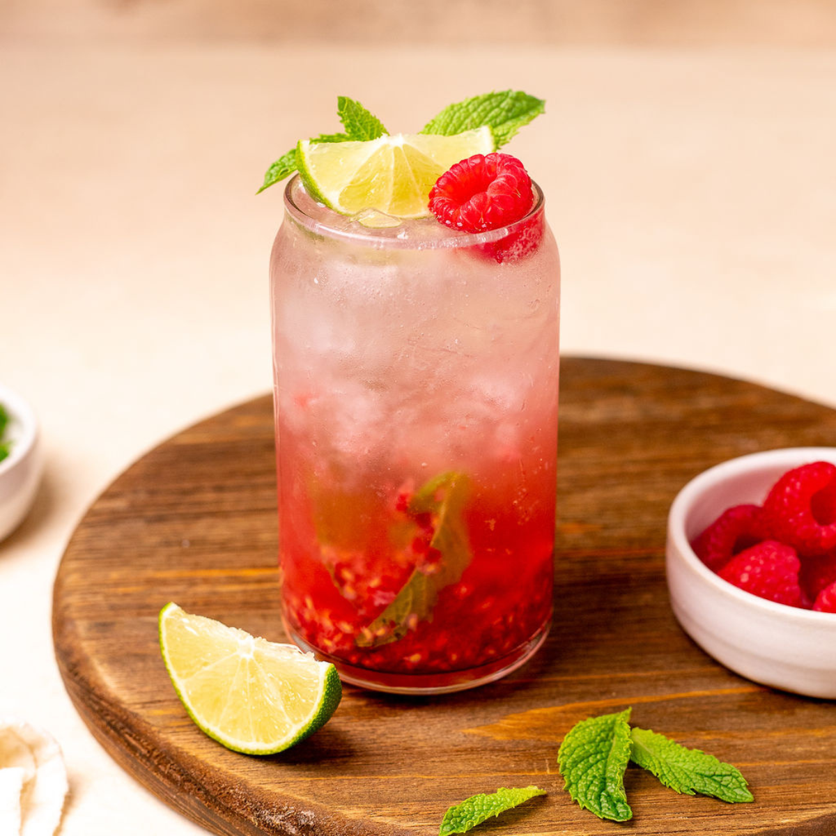 Raspberry nojito with lime wedge, mint spring, and raspberry as a garnish.