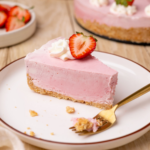 A slice of strawberry icebox pie on a white plate with a fork.