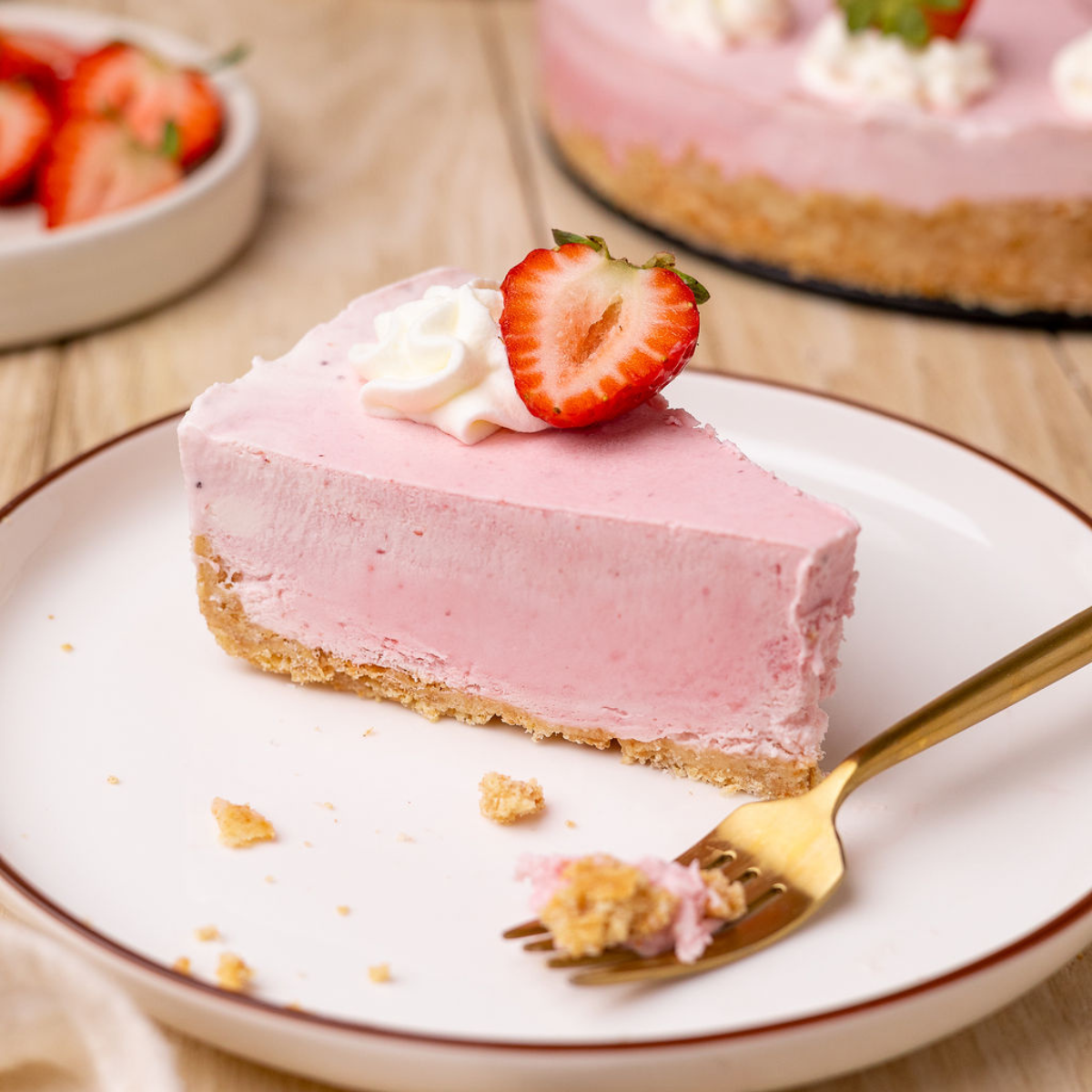 A slice of strawberry icebox pie on a white plate with a fork.