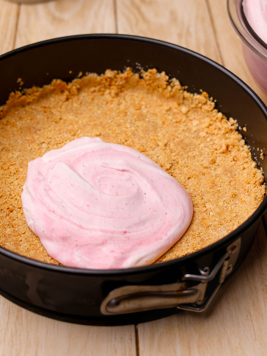 Adding the filling to a graham cracker crust.