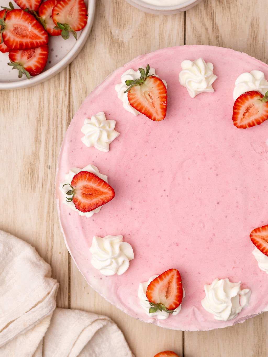 A delicious strawberry icebox pie over a light wooden table.