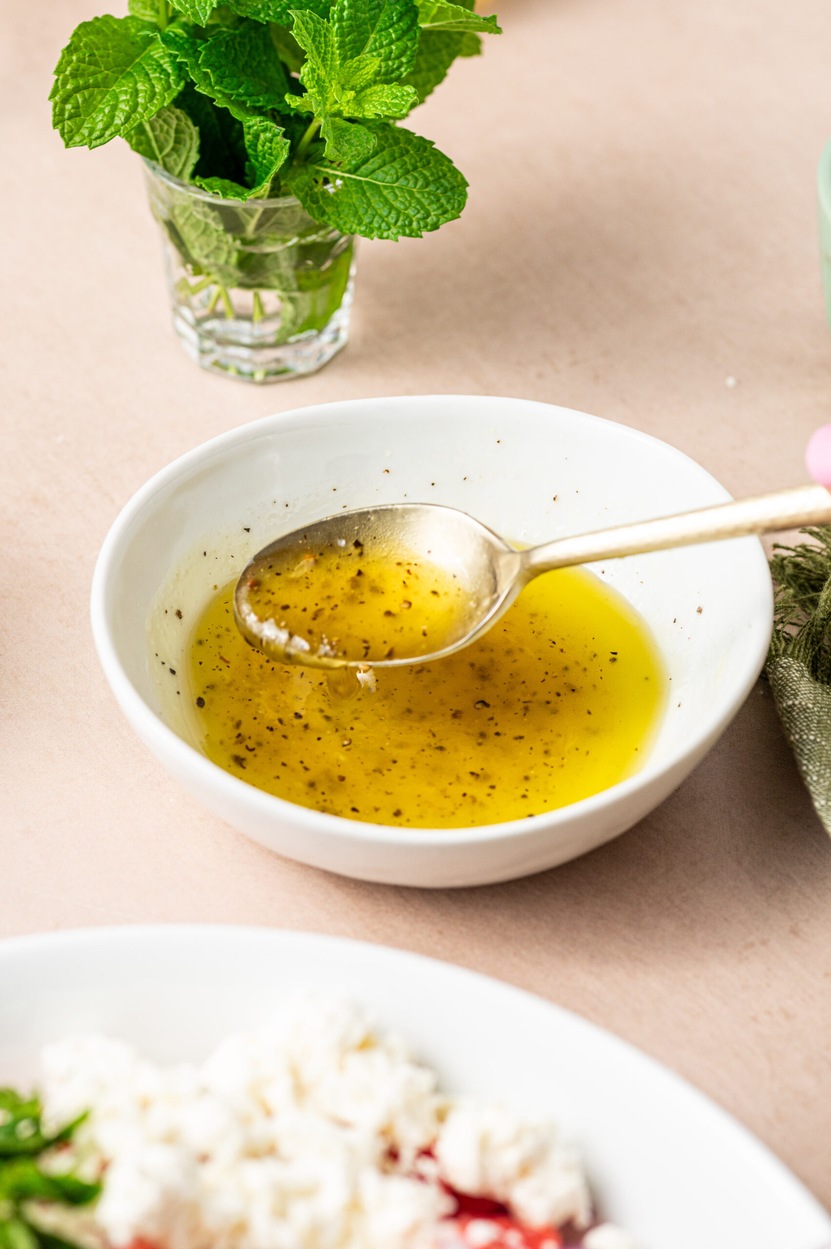 Lemon honey dressing in a white bowl for watermelon feta salad.