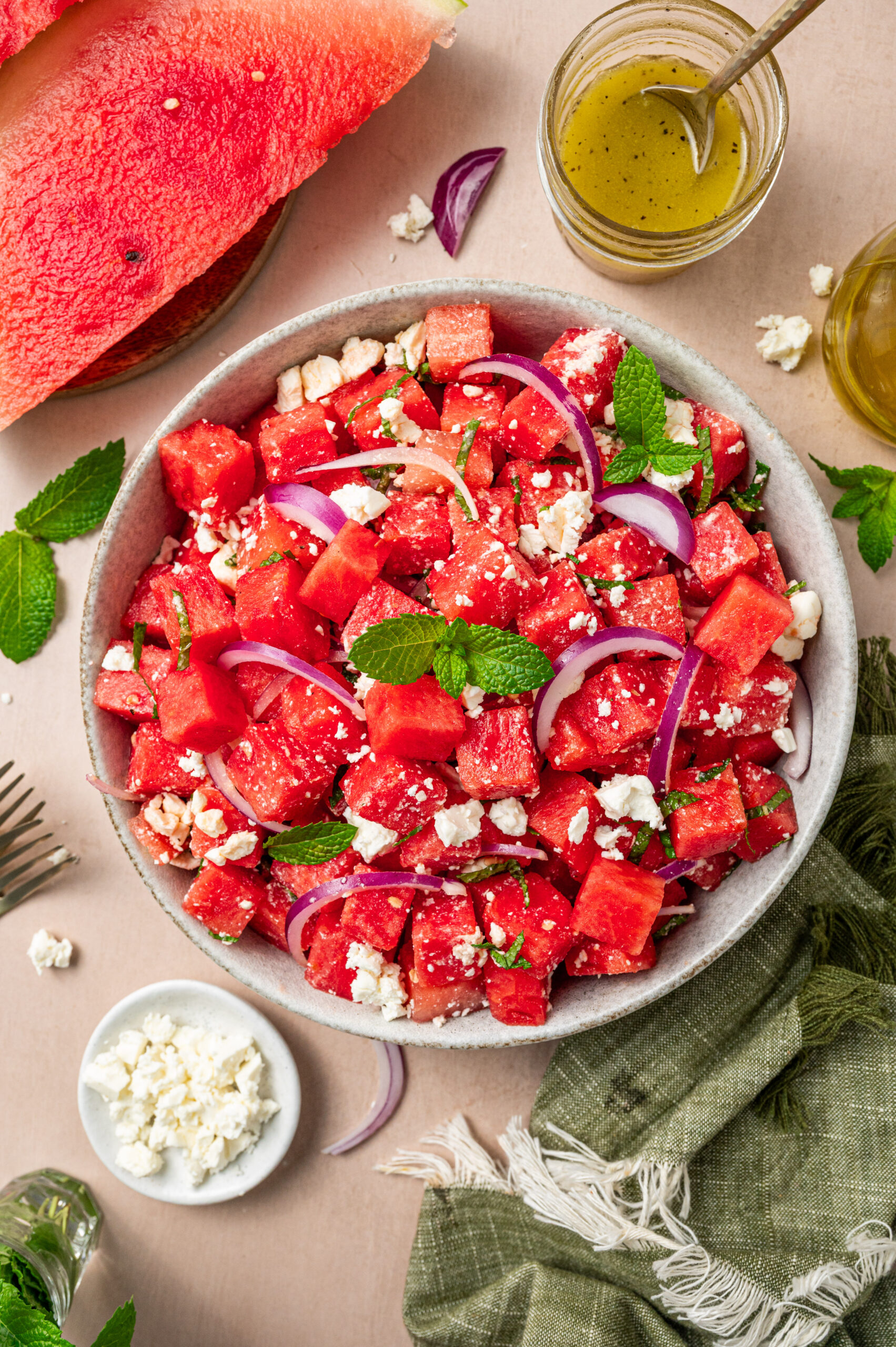 Fresh watermelon feta salad with feta and mint surrounded by ingredients.
