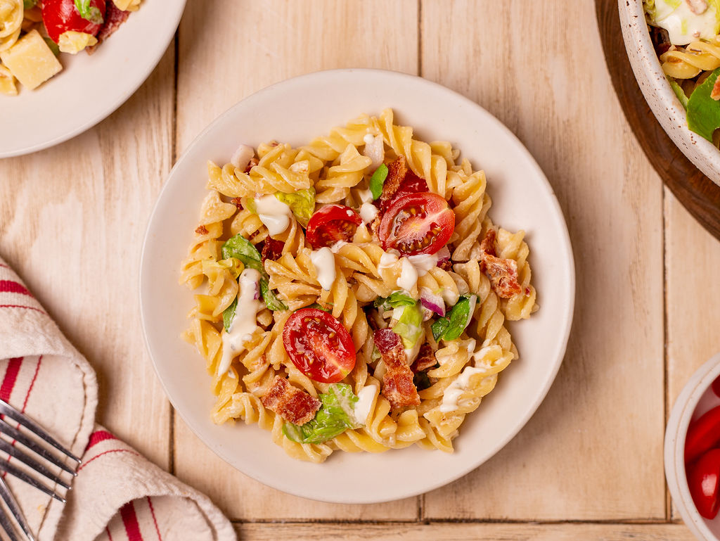 BLT pasta salad on a white plate.