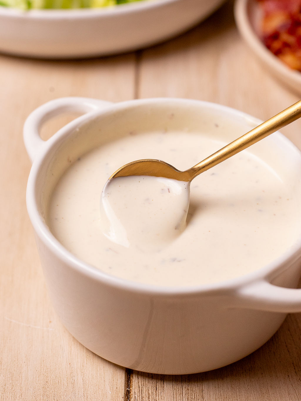 Creamy dressing in a small white bowl.