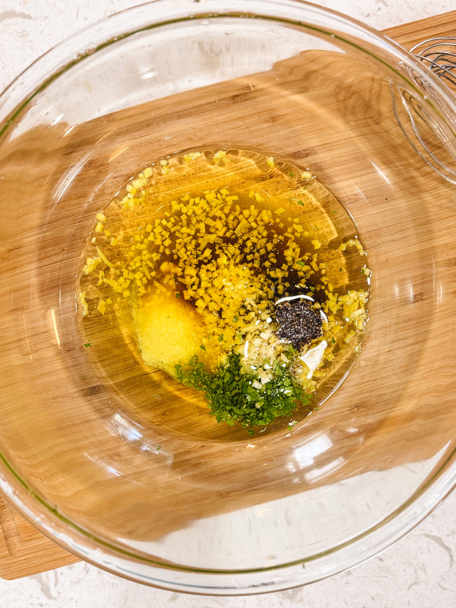 Ingredients for chicken marinade in a glass mixing bowl before getting mixed.