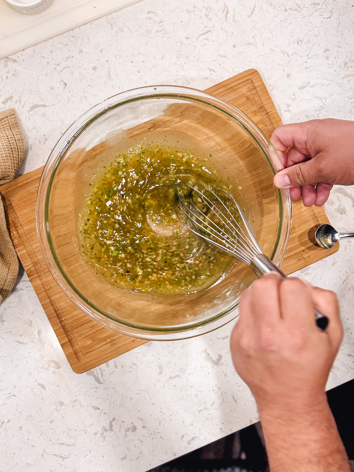 Whisking the ingredients together for chicken marinade in a glass mixing bowl.