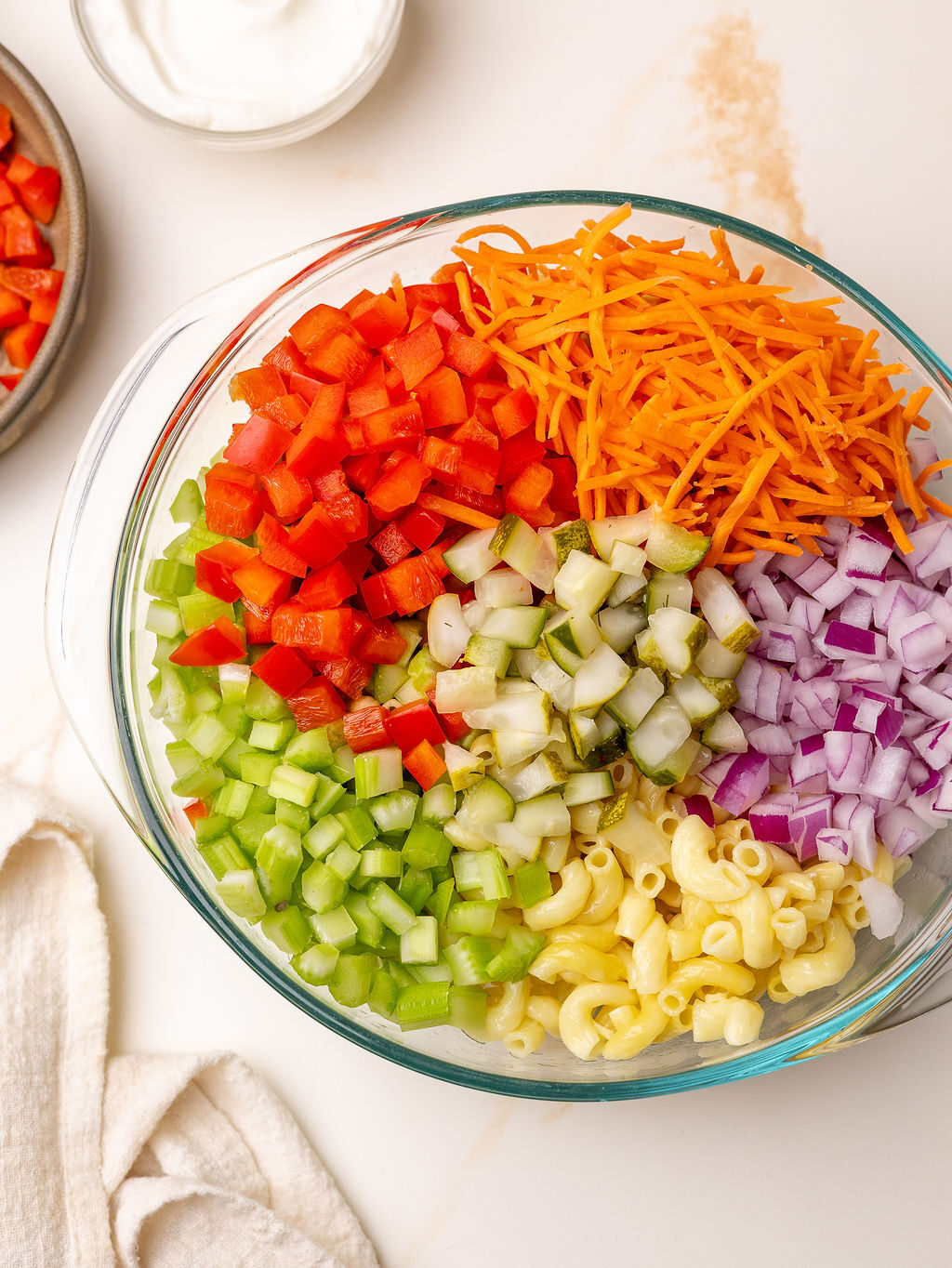 Fresh vegetables in a glass mixing bowl before stirring.