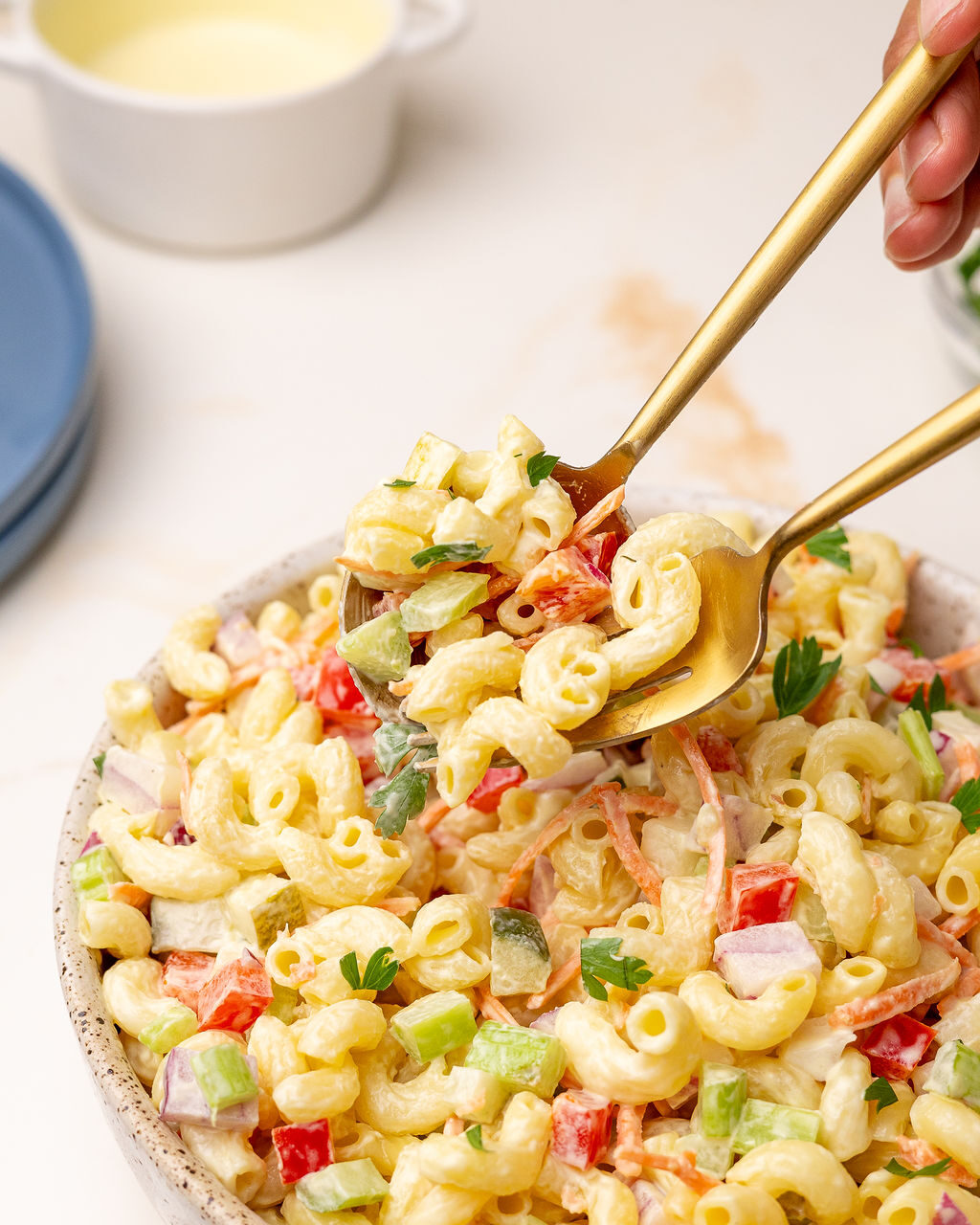 Using two forks to serve macaroni pasta salad.