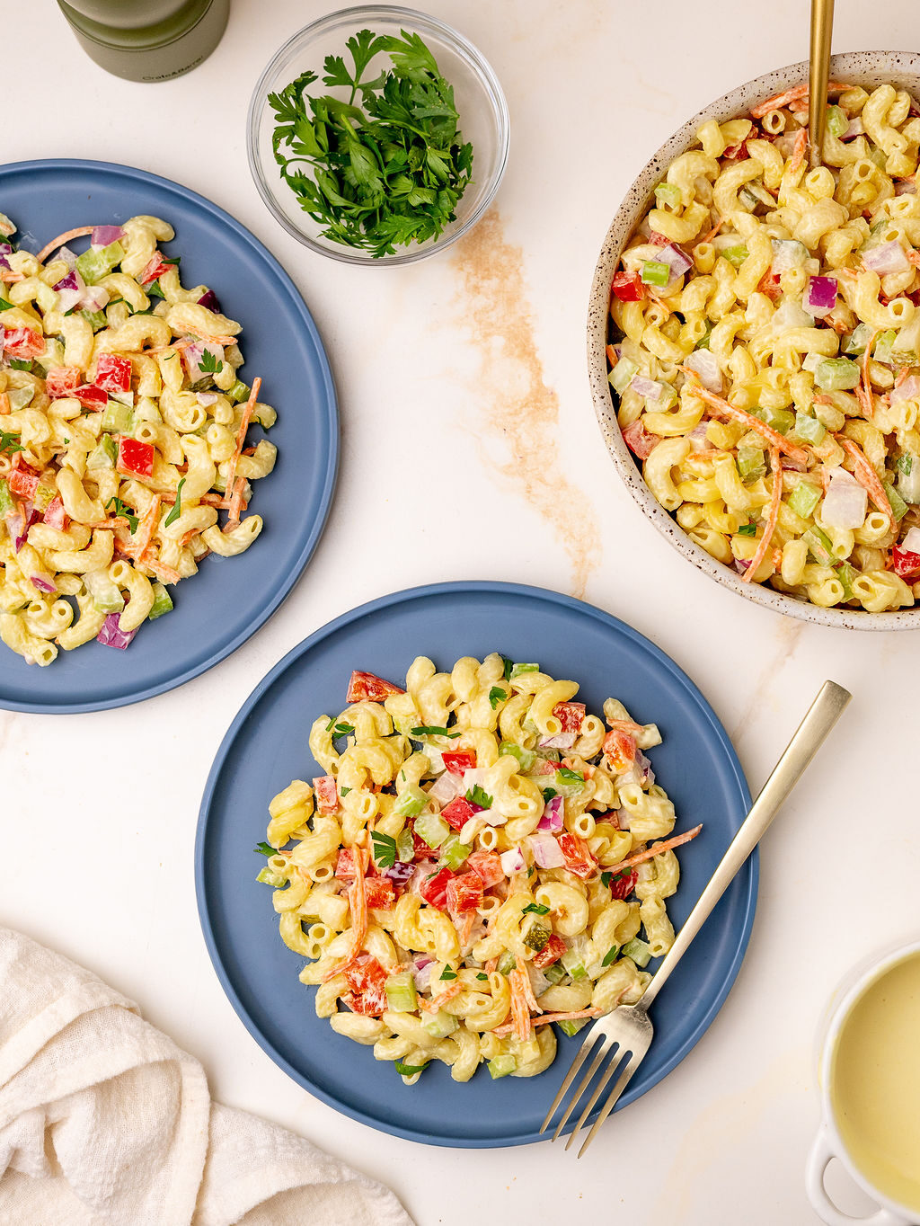 Two servings of macaroni salad on blue plates.
