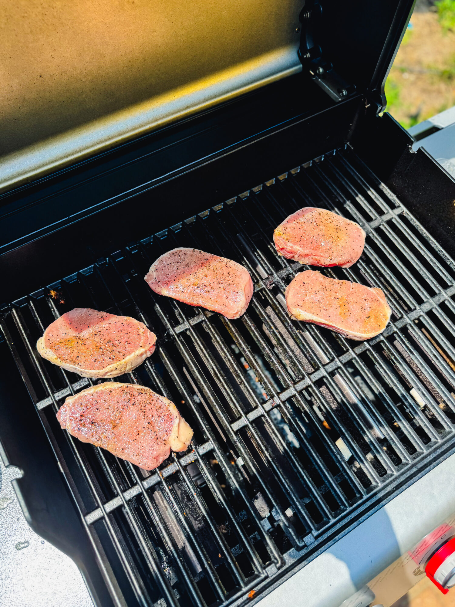 Lemon Dijon pork chops cooking on a grill.