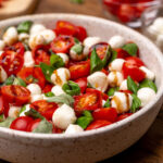 Caprese salad in a bowl with balsamic glaze.
