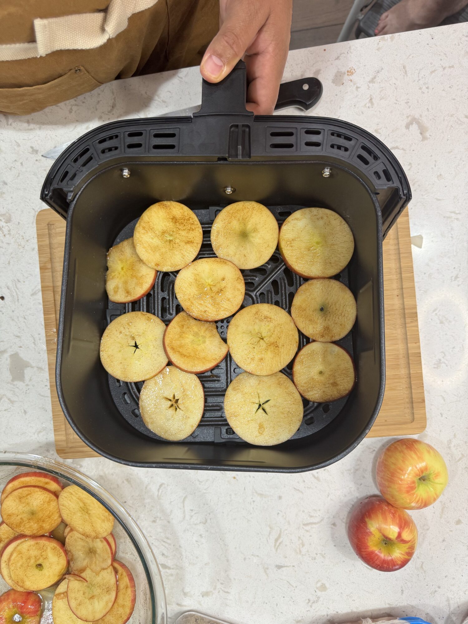 Apple rounds in an air fryer basket.
