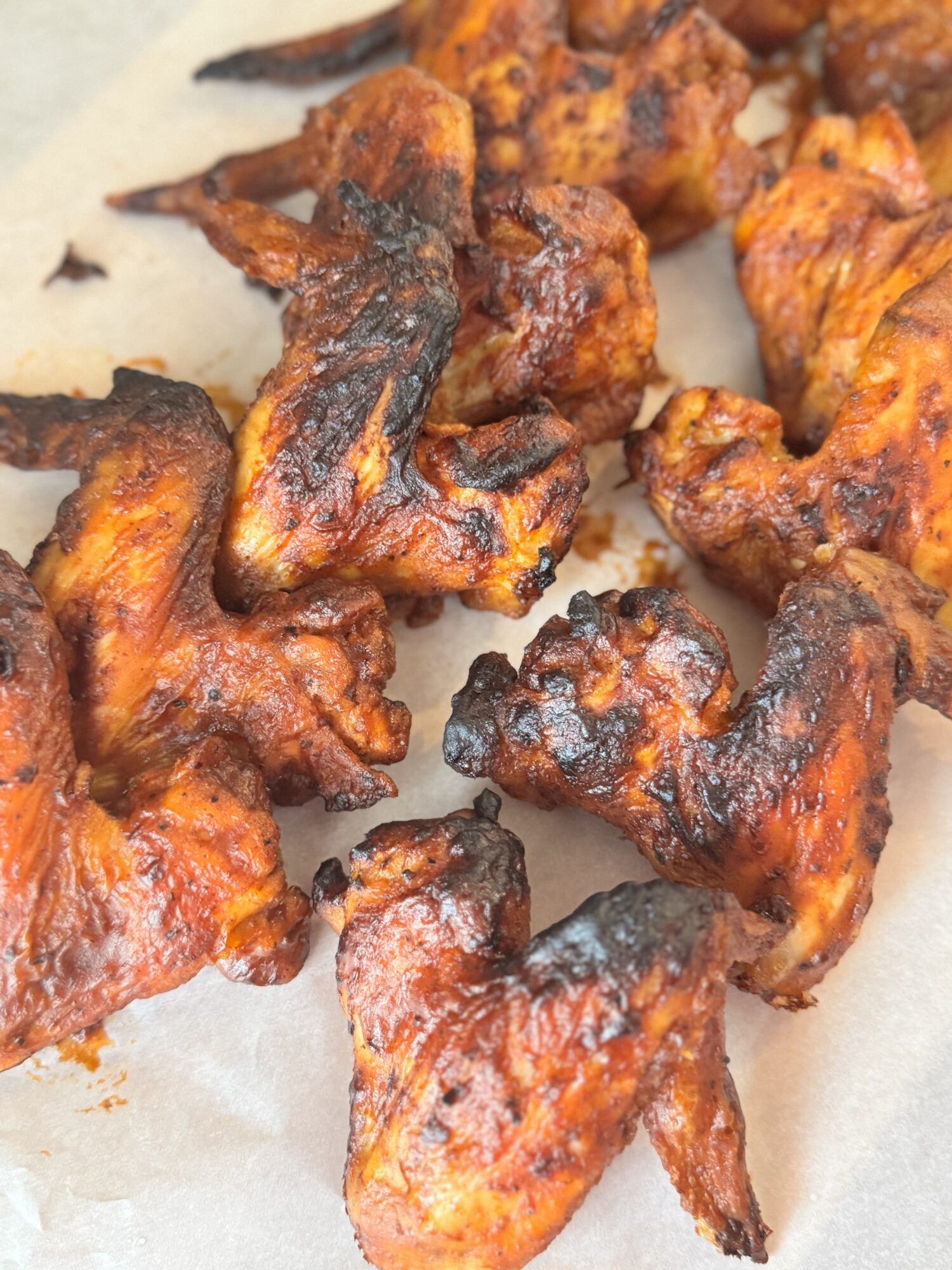 Air fryer BBQ chicken wings on parchment paper.