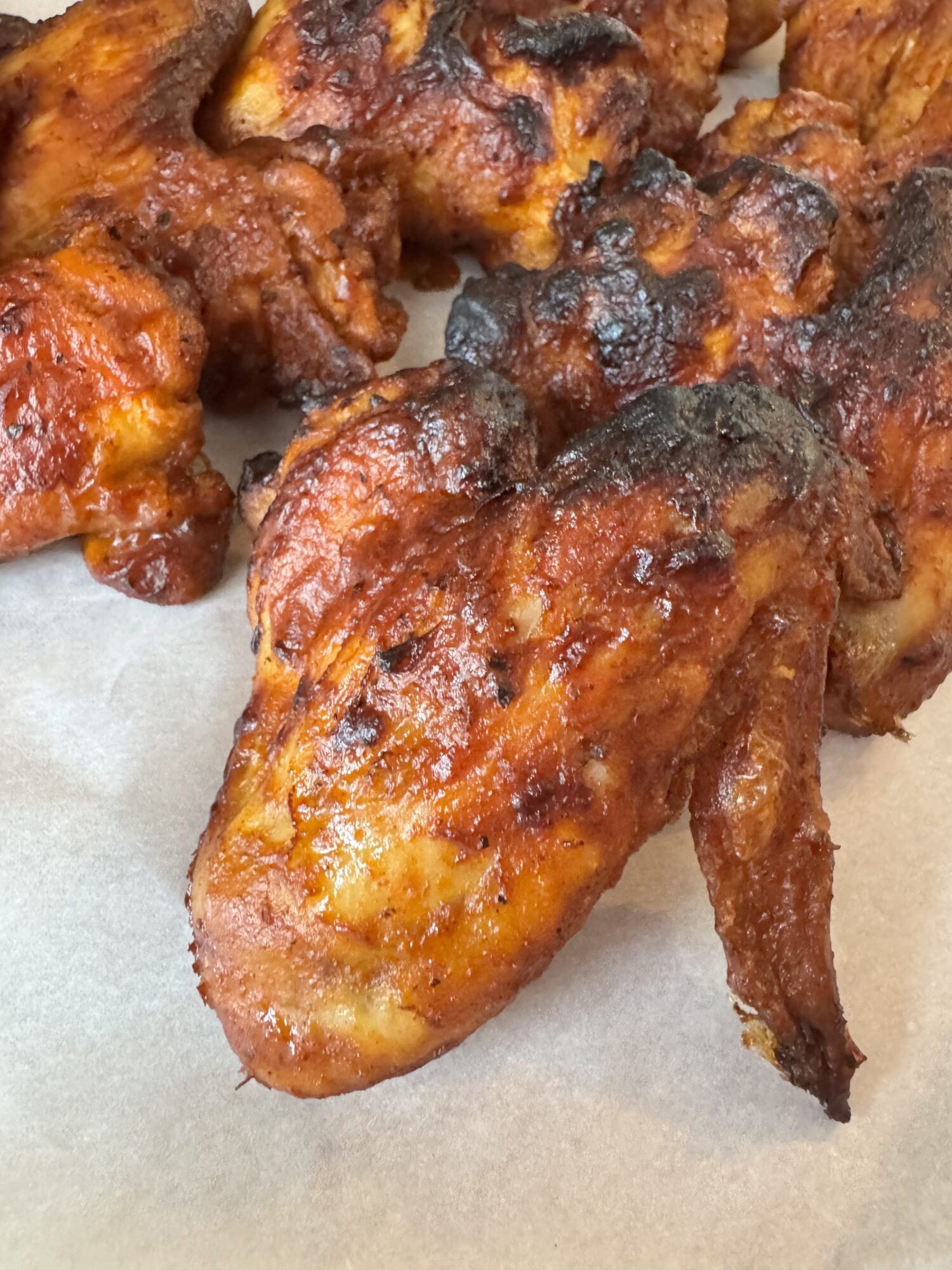 Close-up of crispy air fryer BBQ chicken wings.