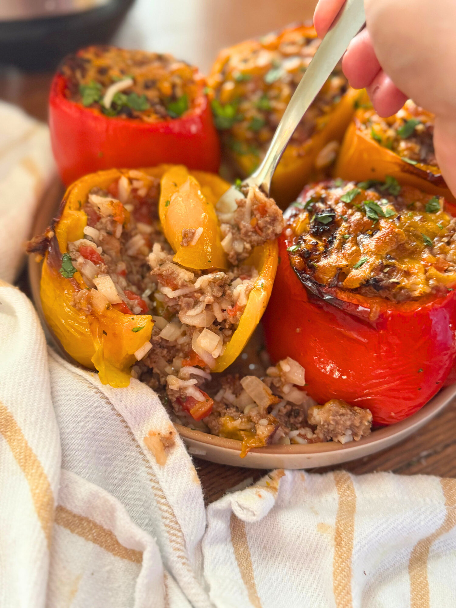 Digging a fork into a plate of air fryer stuffed peppers.