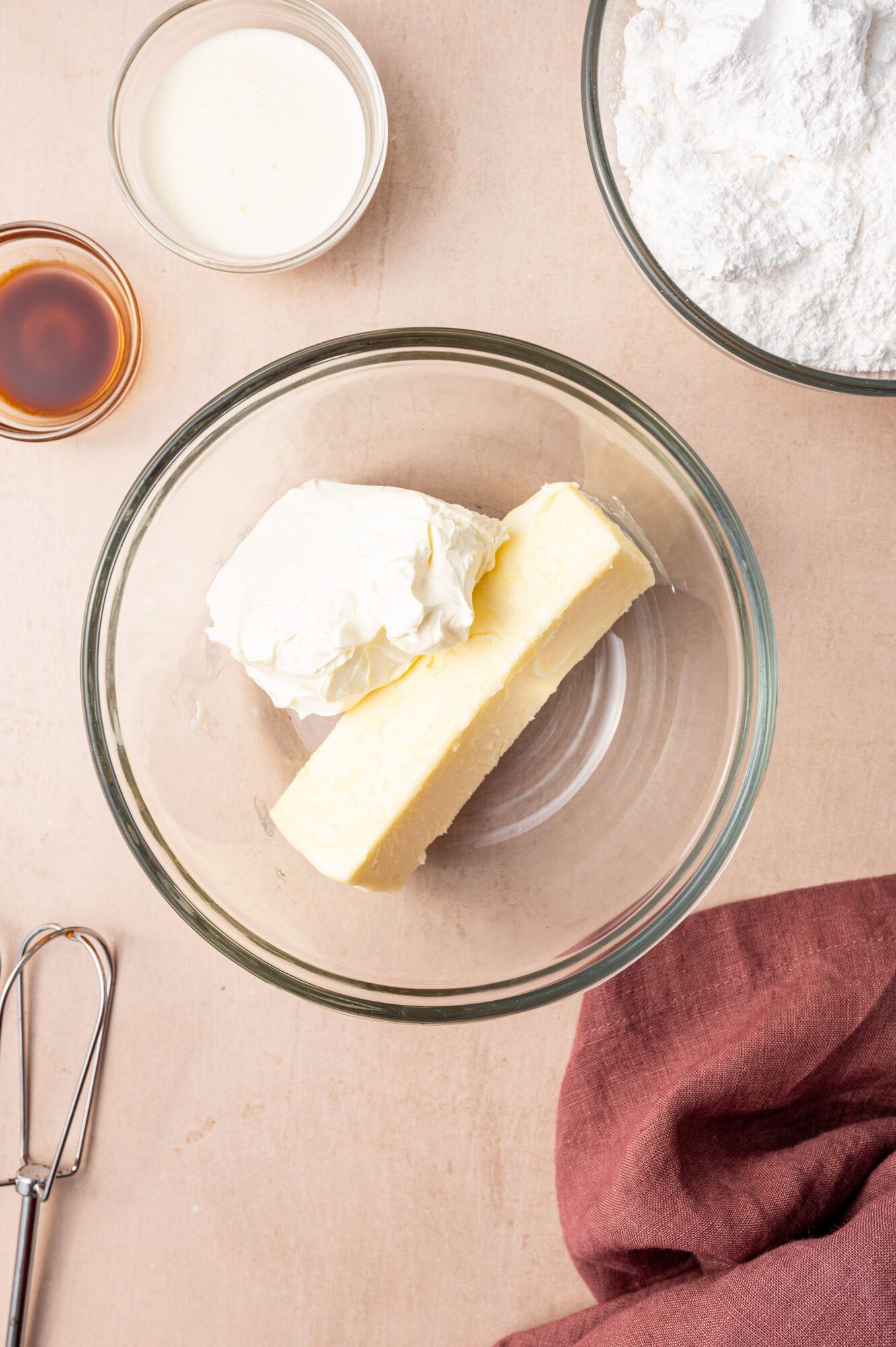 Ingredients for cream cheese frosting in a glass bowl.