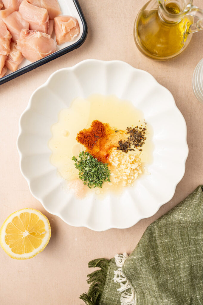 Olive oil, lemon juice, and spices in a dish before mixing.
