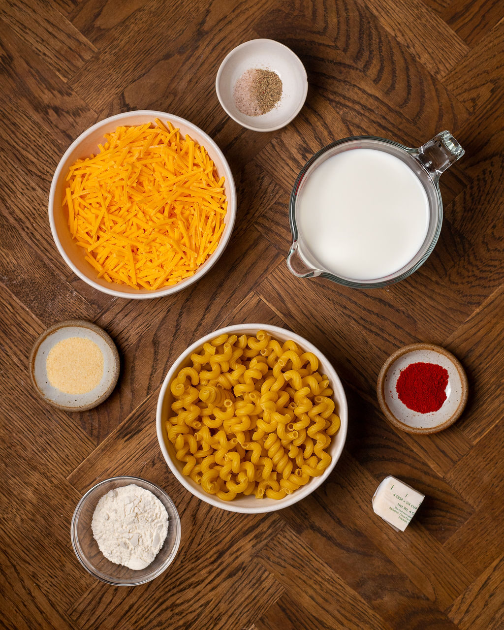 Ingredients for stovetop mac and cheese on a dark wooden surface.