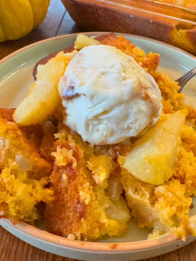 Pumpkin pear cobbler on a plate with vanilla ice cream.