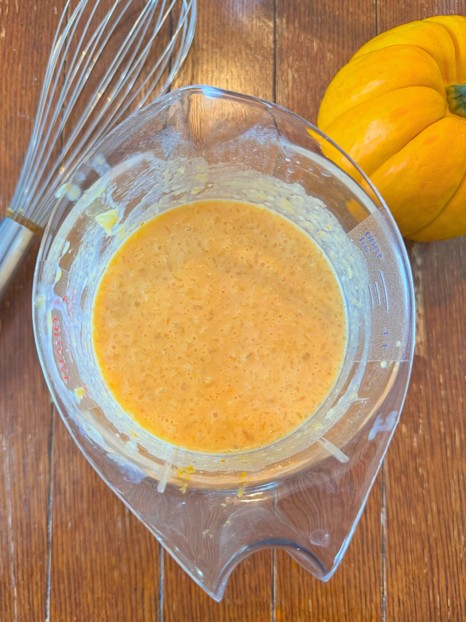 Wet ingredients for pumpkin pear cobbler in a glass bowl.