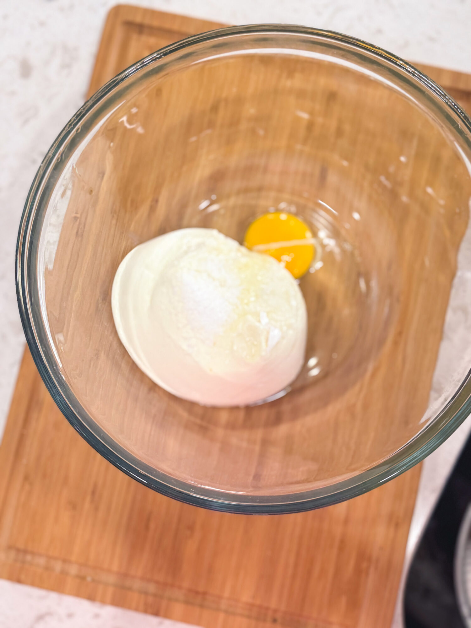 Ricotta cheese and egg in a glass bowl.