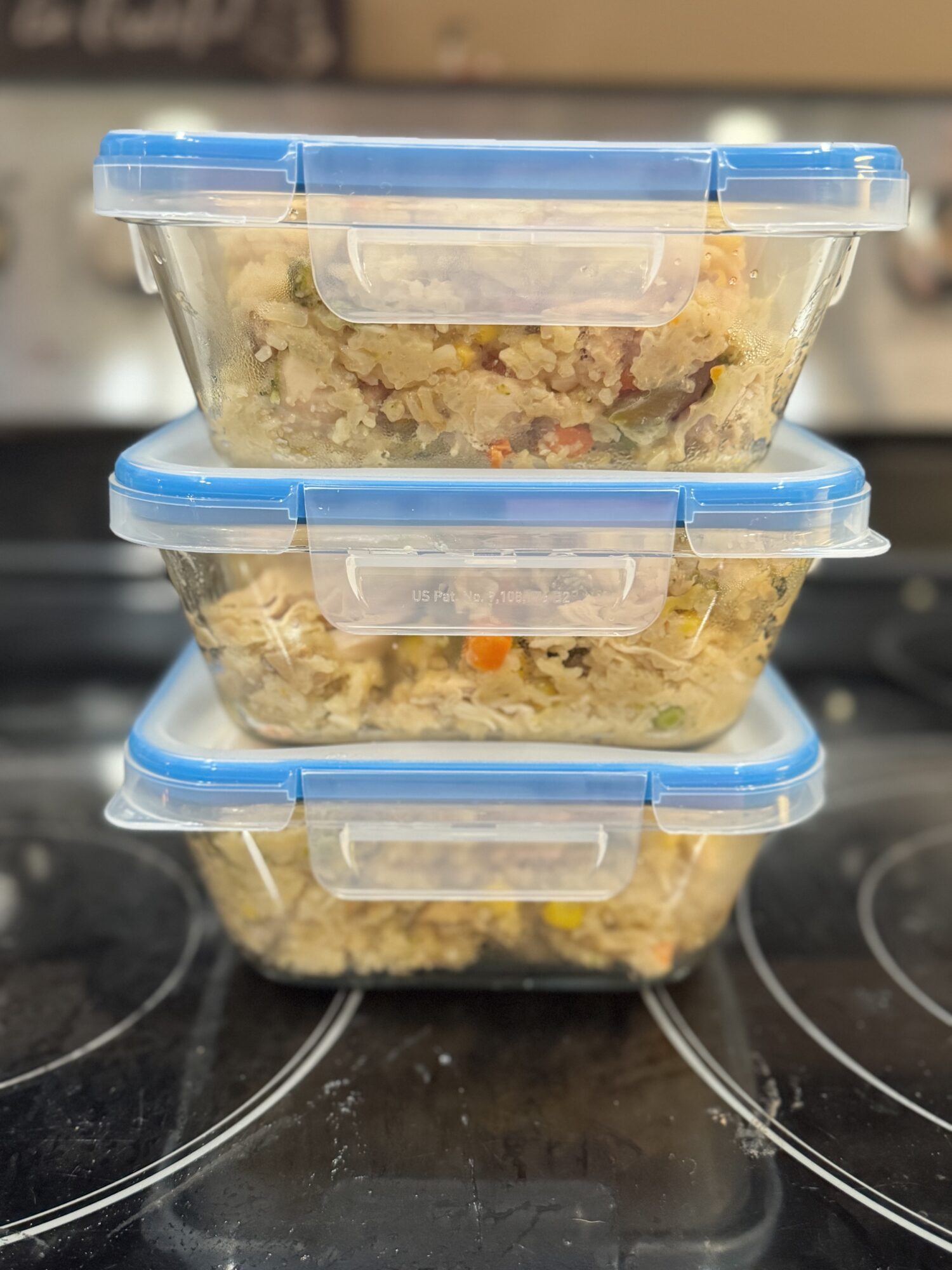 Slow cooker chicken and rice stacked in glass meal prep containers.