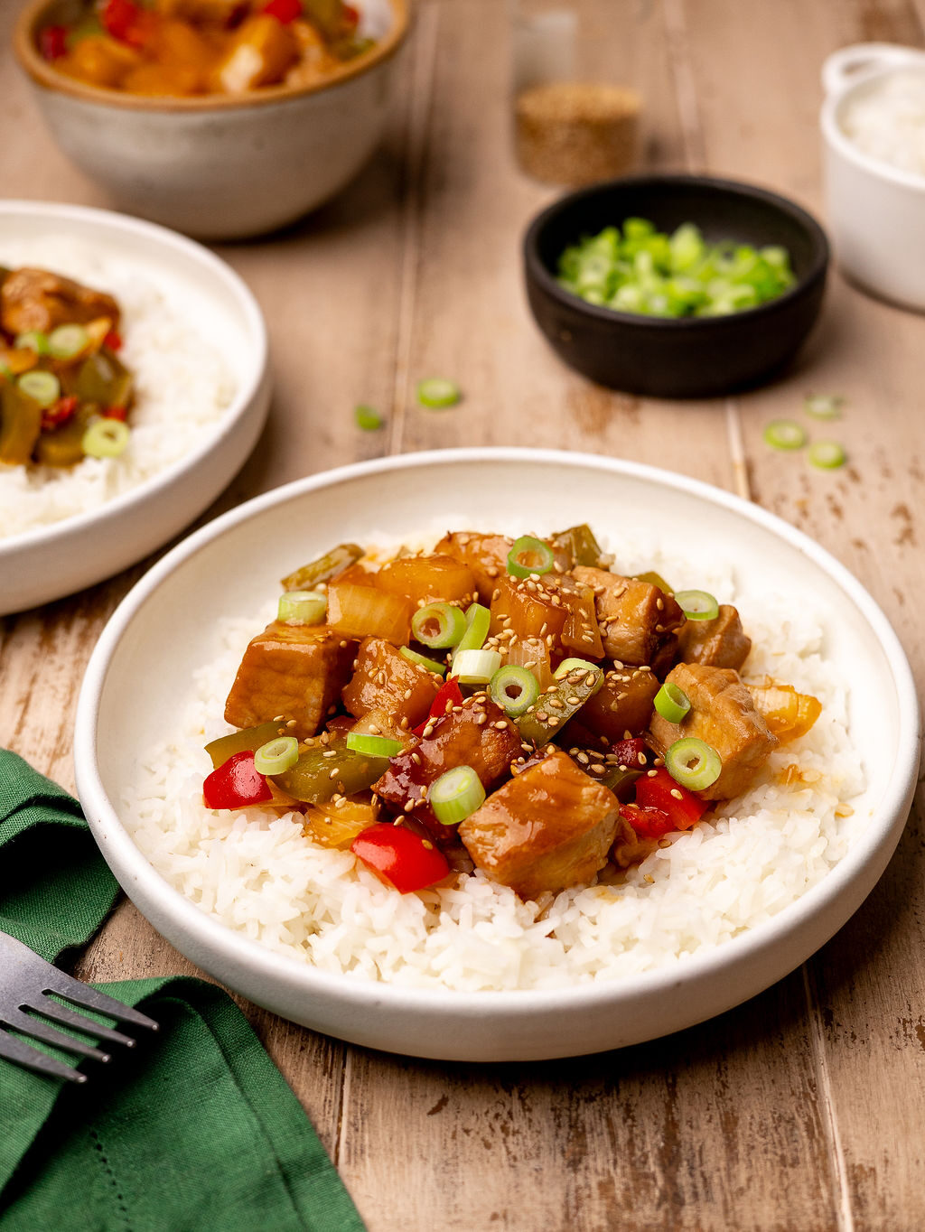 A bowl of sweet and sour pork on a bed of white rice.