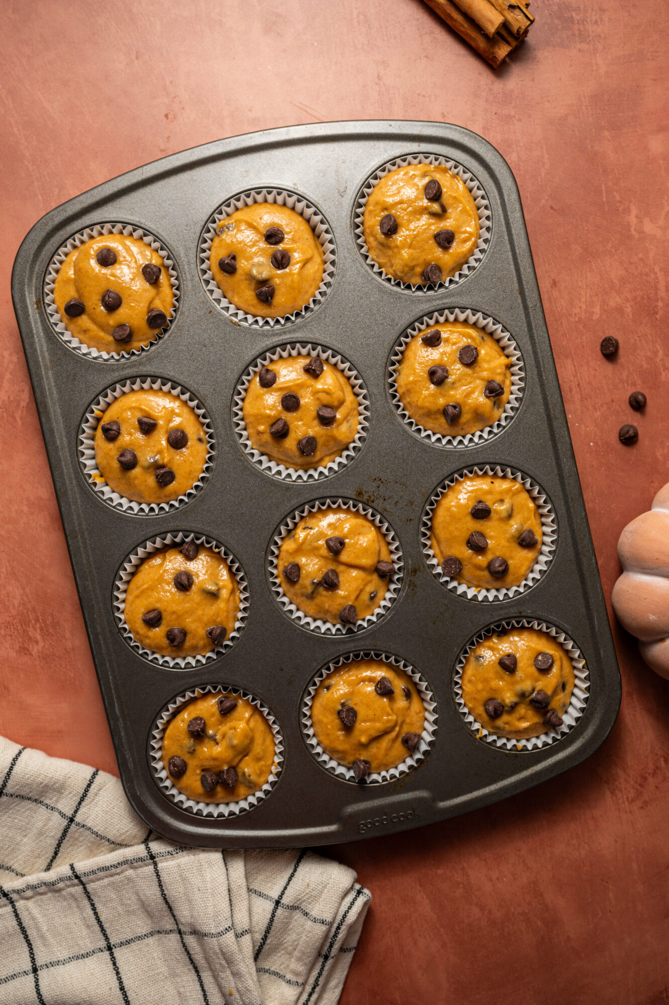 Chocolate chip pumpkin muffins in a muffin pan ready to bake.