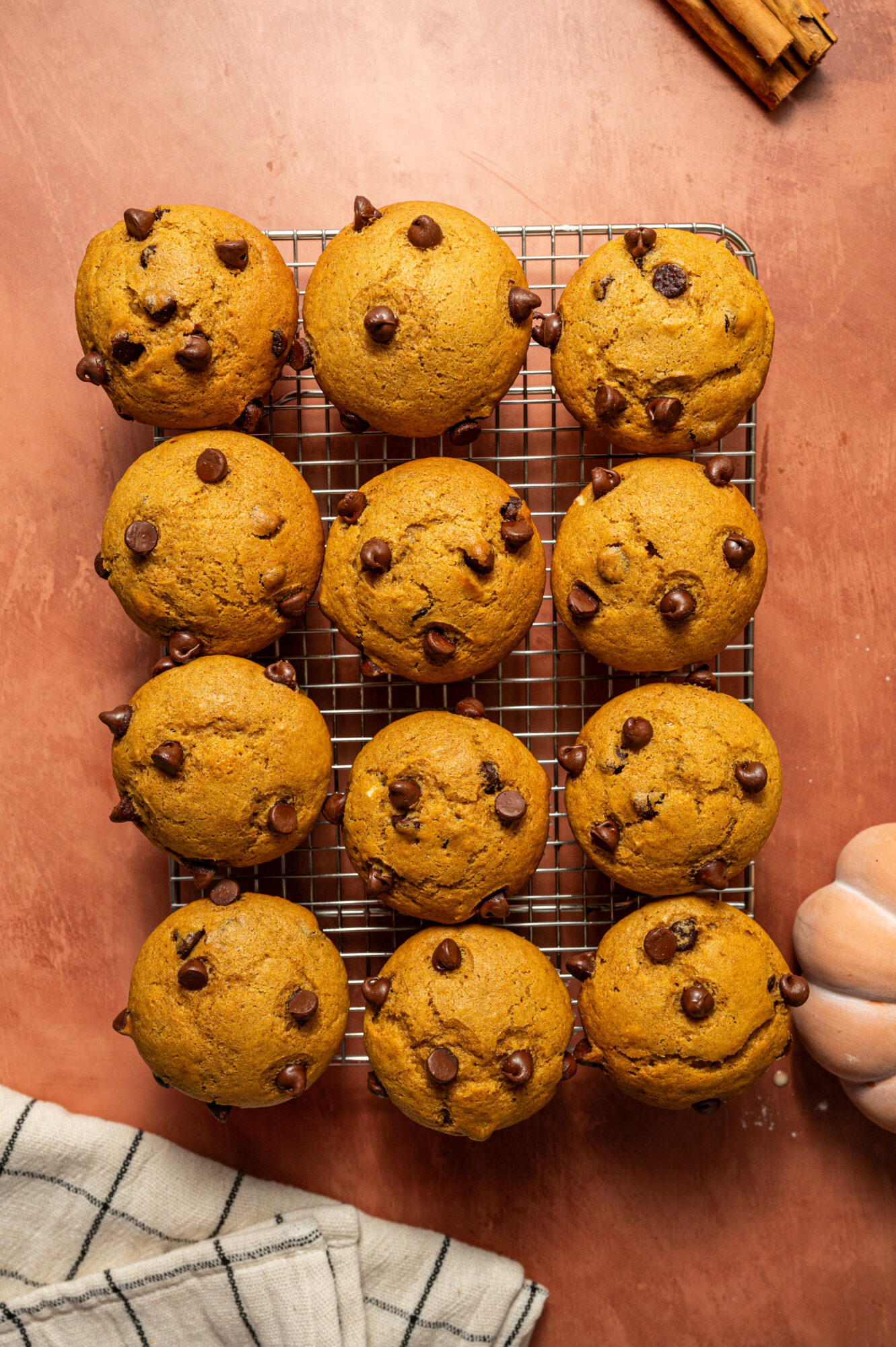 Chocolate chip pumpkin muffins on a cooling rack.