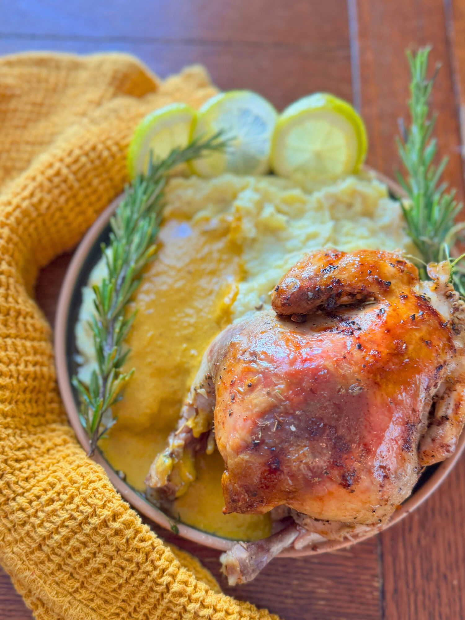 A serving of cornish hens on a plate with mashed potatoes.