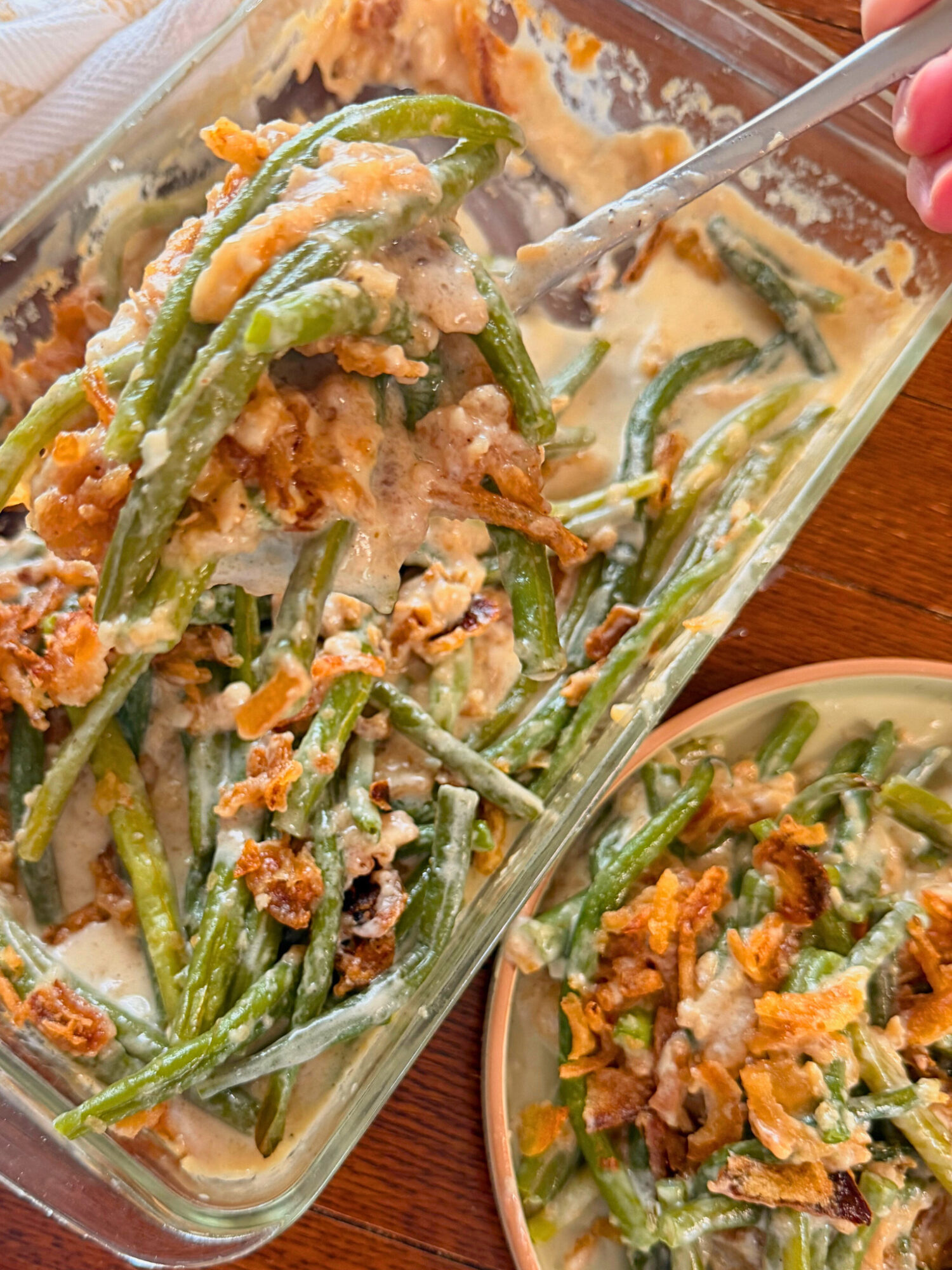Serving green bean casserole into a bowl.
