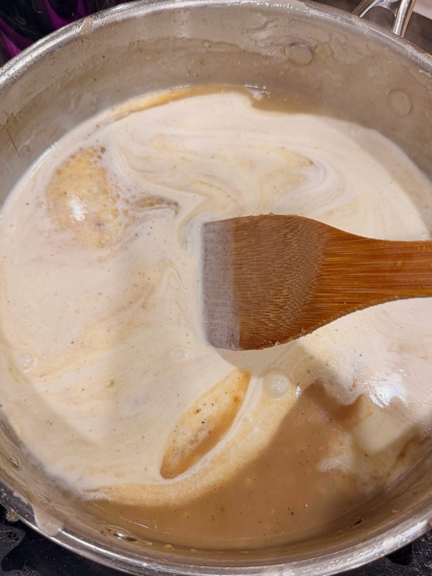 Stirring liquid ingredients in a pot over the stove.