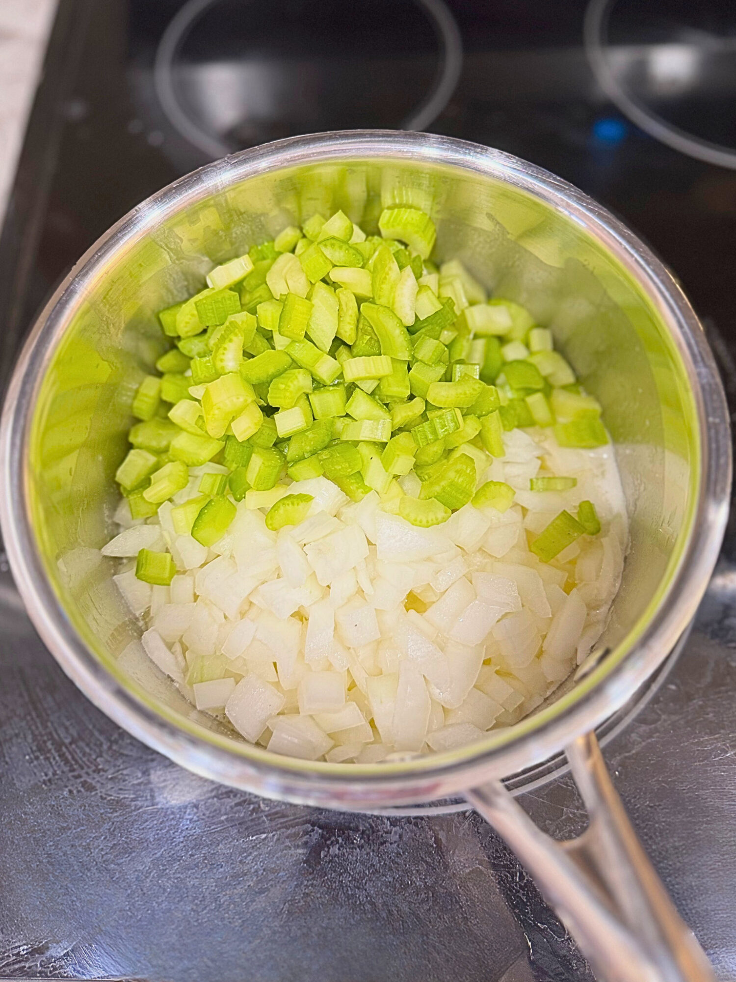 Diced celery, garlic, and onion in a pot over the stove.