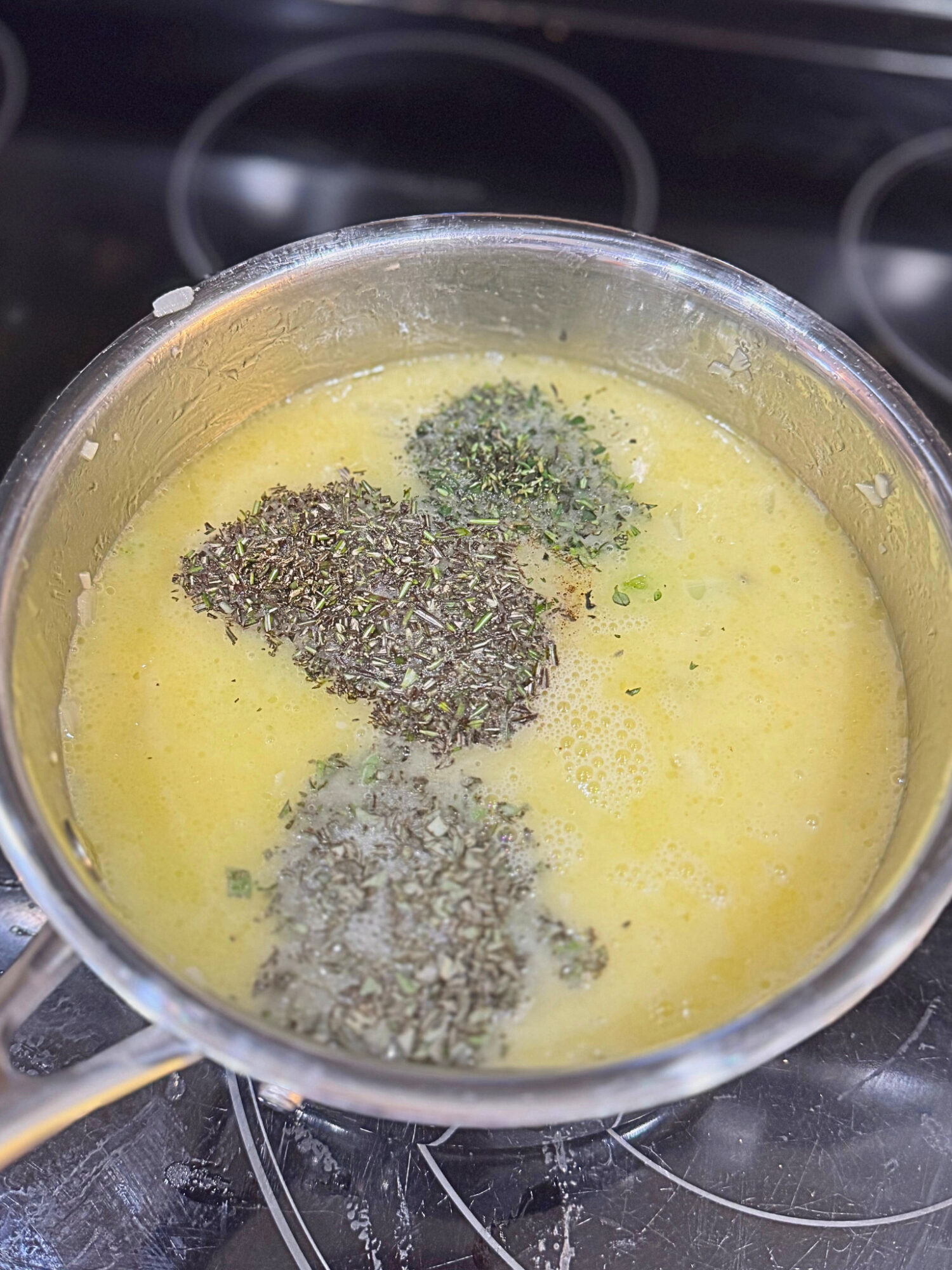 Wet ingredients for homemade stuffing in a pot over the stove.