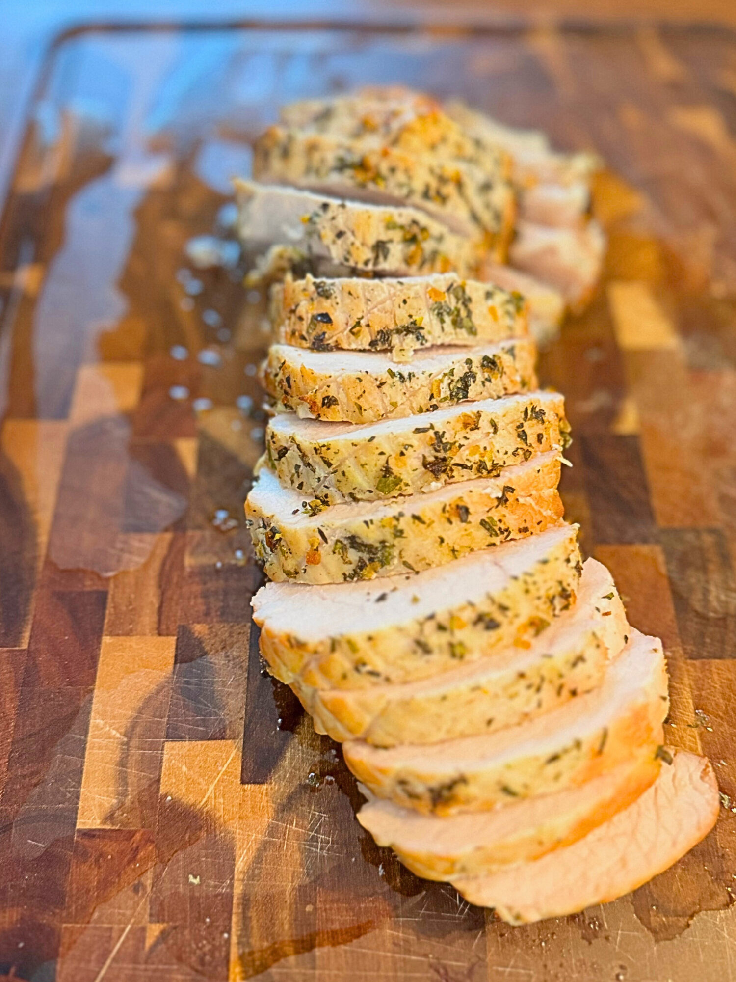 Sliced oven-roasted turkey breast on a wooden cutting board.