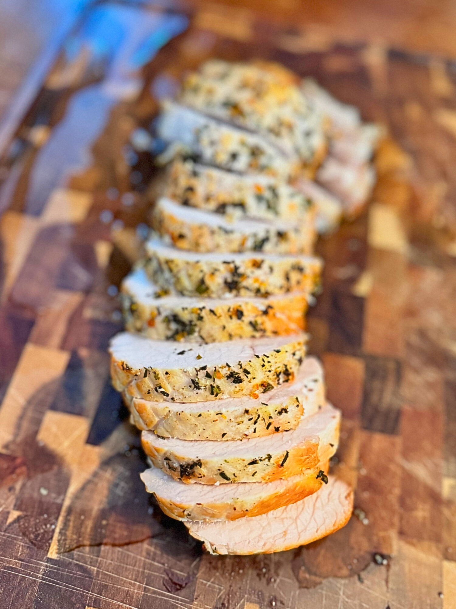 Sliced oven-roasted turkey breast on a wooden cutting board.