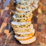 Sliced oven-roasted turkey breast on a wooden cutting board.