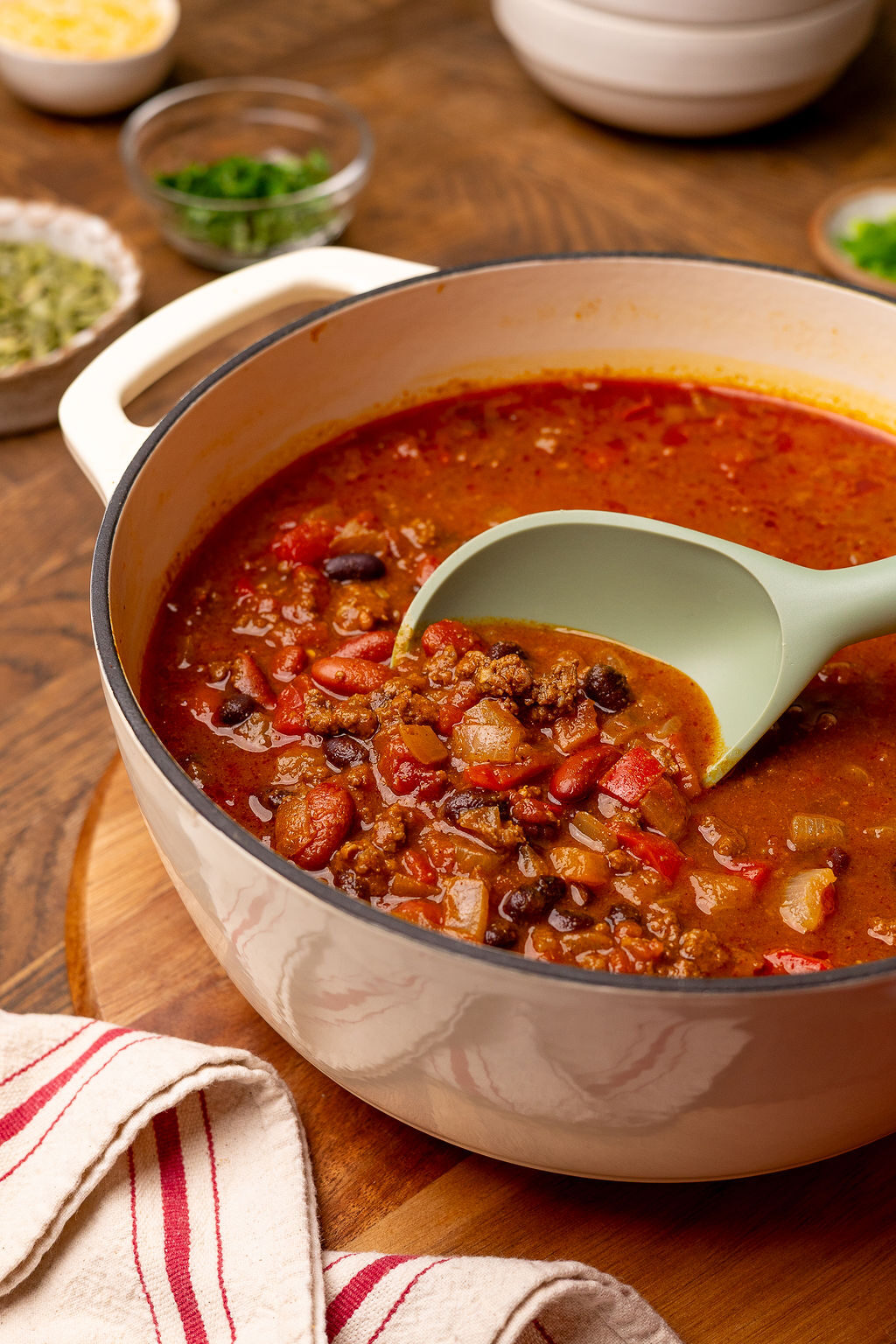 Pumpkin chili in a Dutch oven with a serving spoon ready to eat.