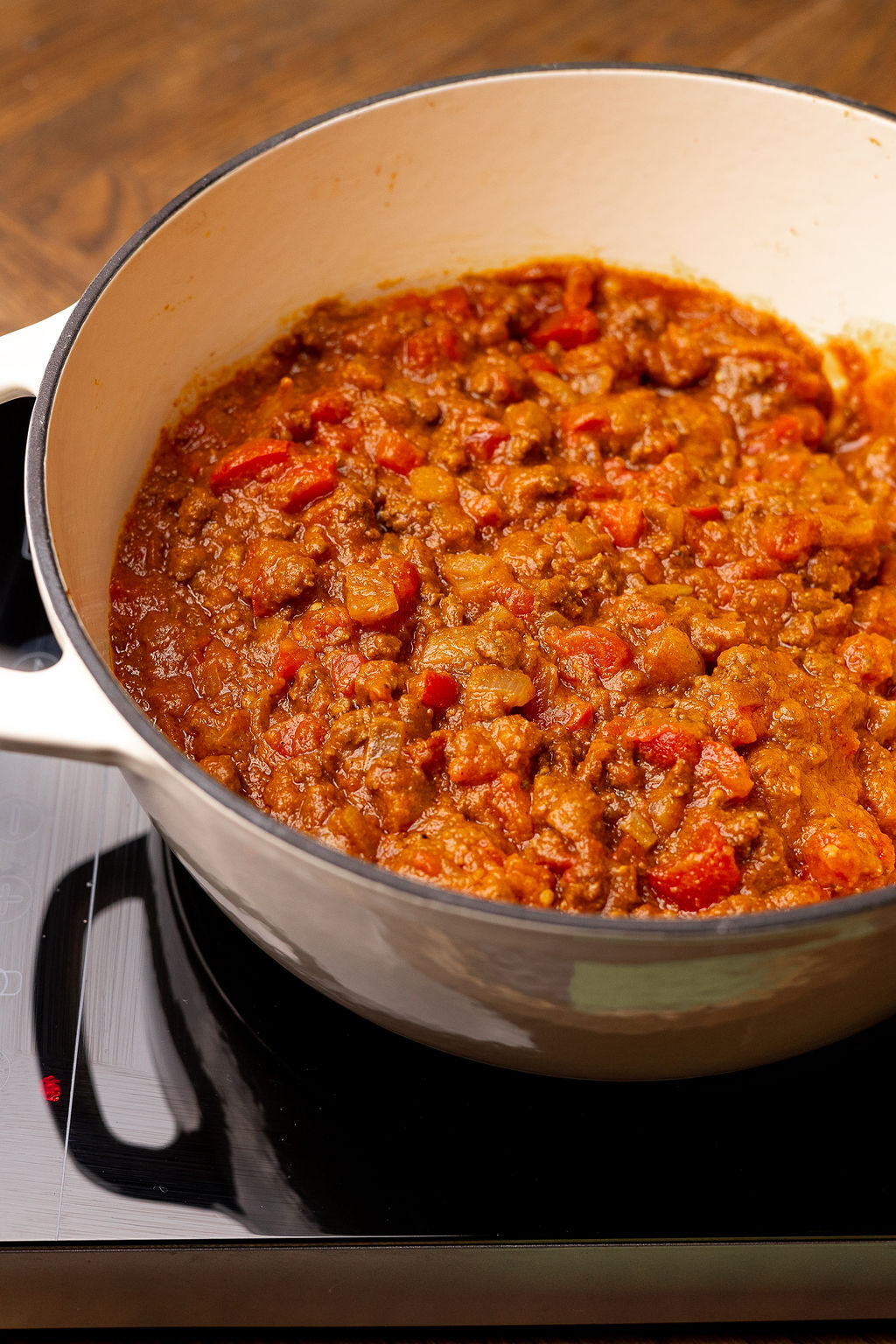 A Dutch oven of pumpkin chili over a stove.