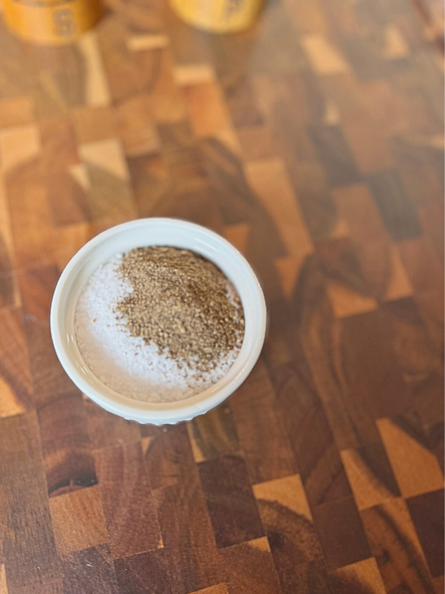 10 parts salt and 1 part pepper in a shallow dish over a wooden surface.