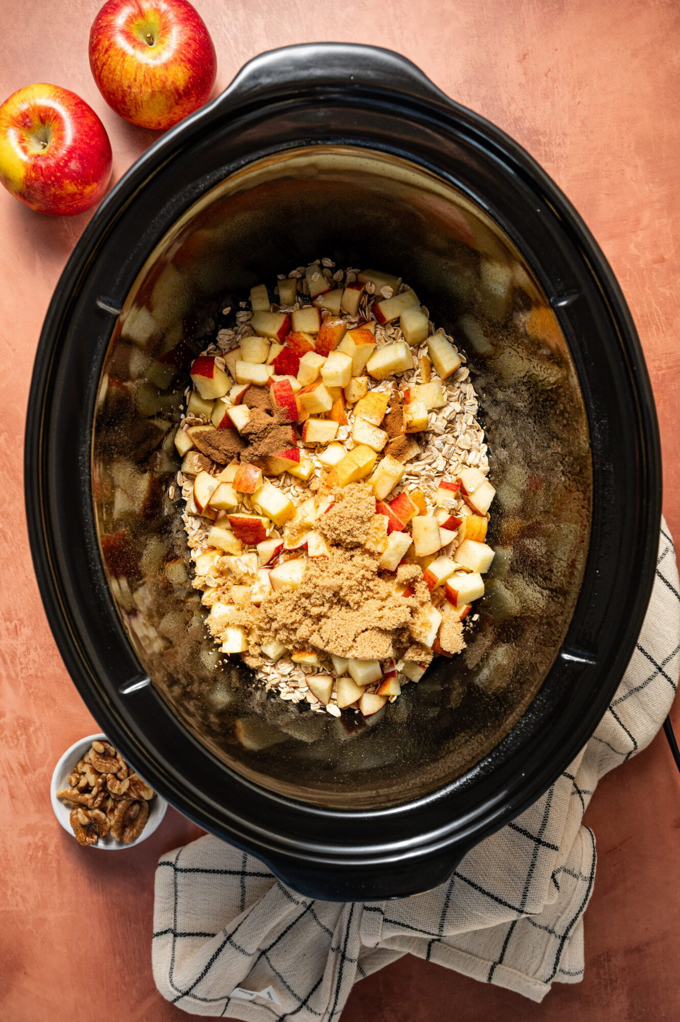 Ingredients for apple cinnamon oatmeal in a slow cooker ready to cook.
