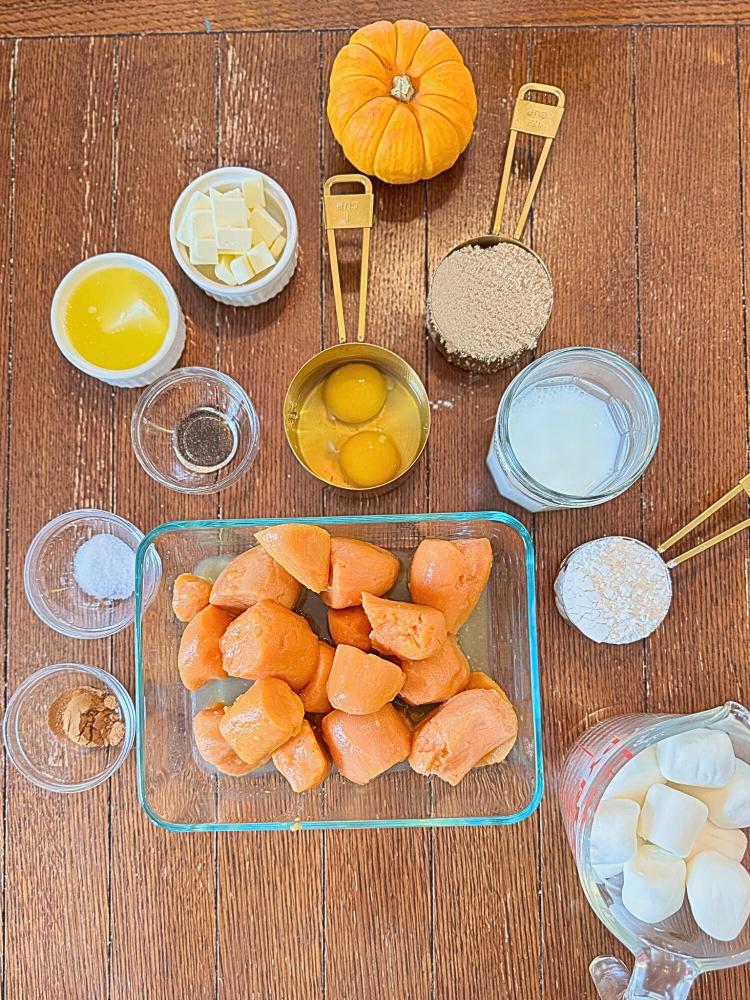 Ingredients for sweet potato casserole on a wooden table.