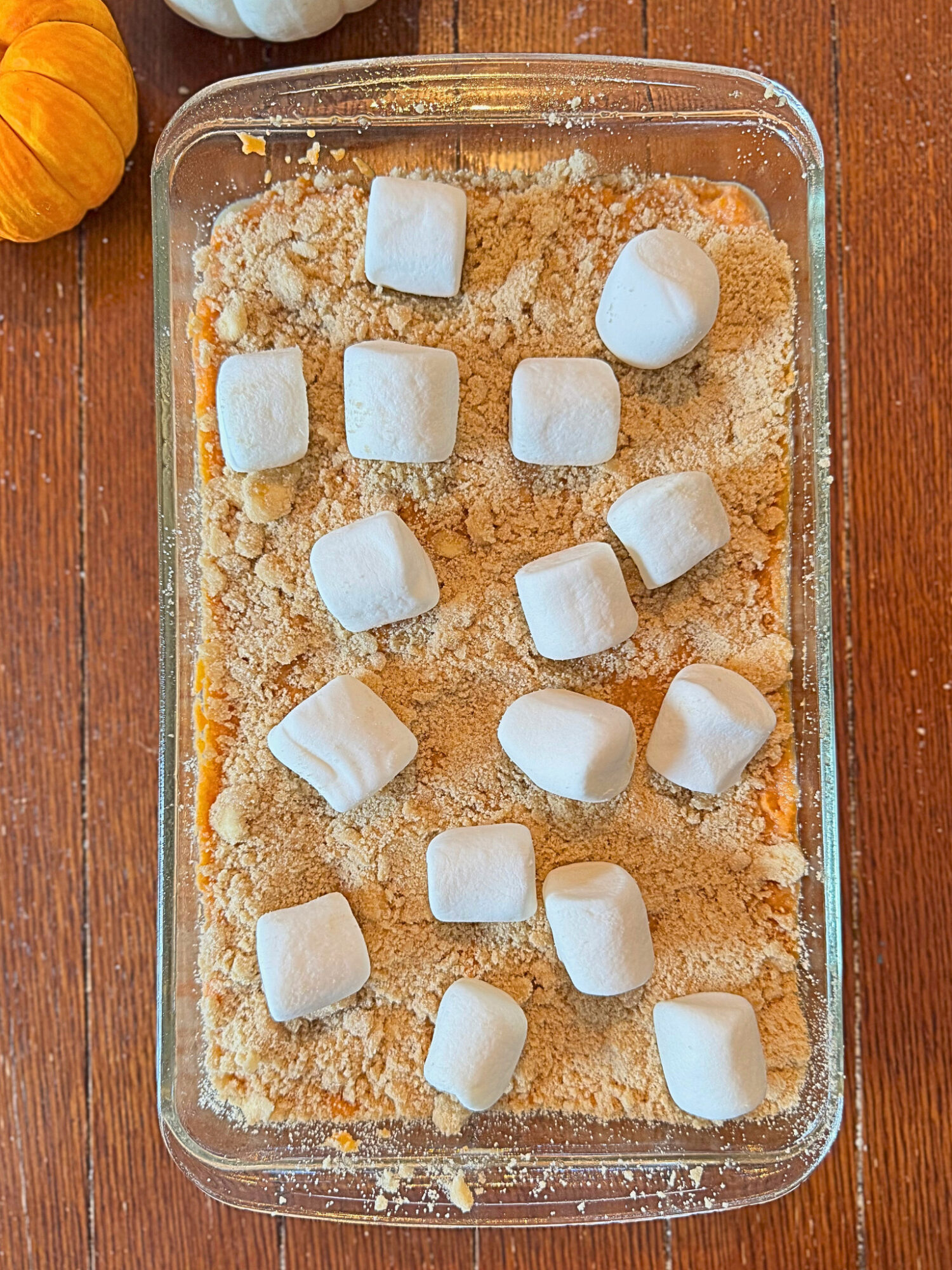 Assembled sweet potato casserole with marshmallows on top ready to bake.
