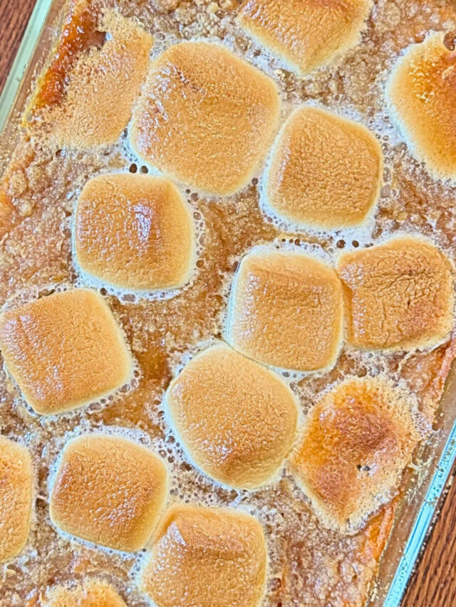 Sweet potato casserole in a casserole dish on a wooden table.