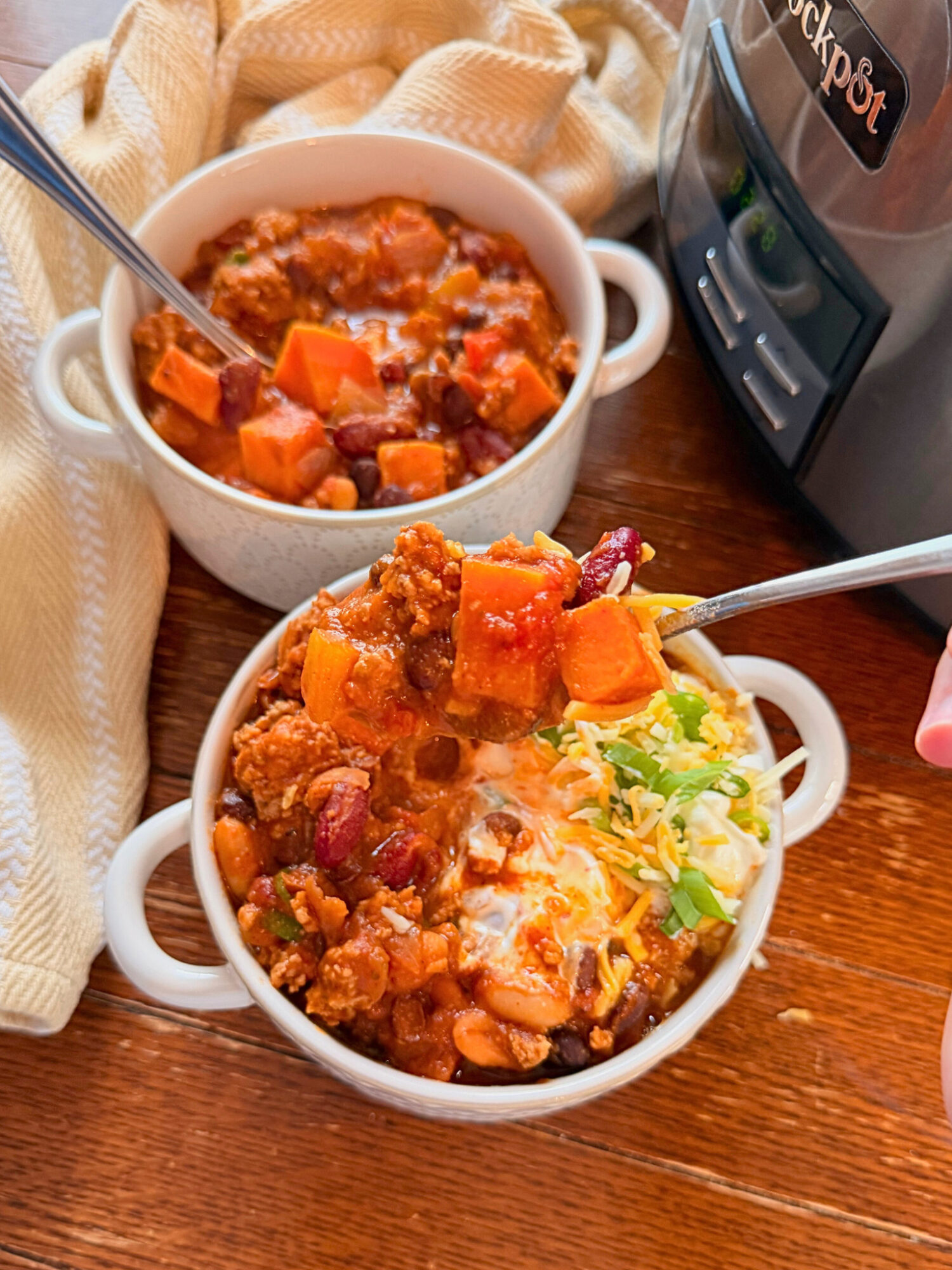 Two bowls of turkey and sweet potato chili with toppings.