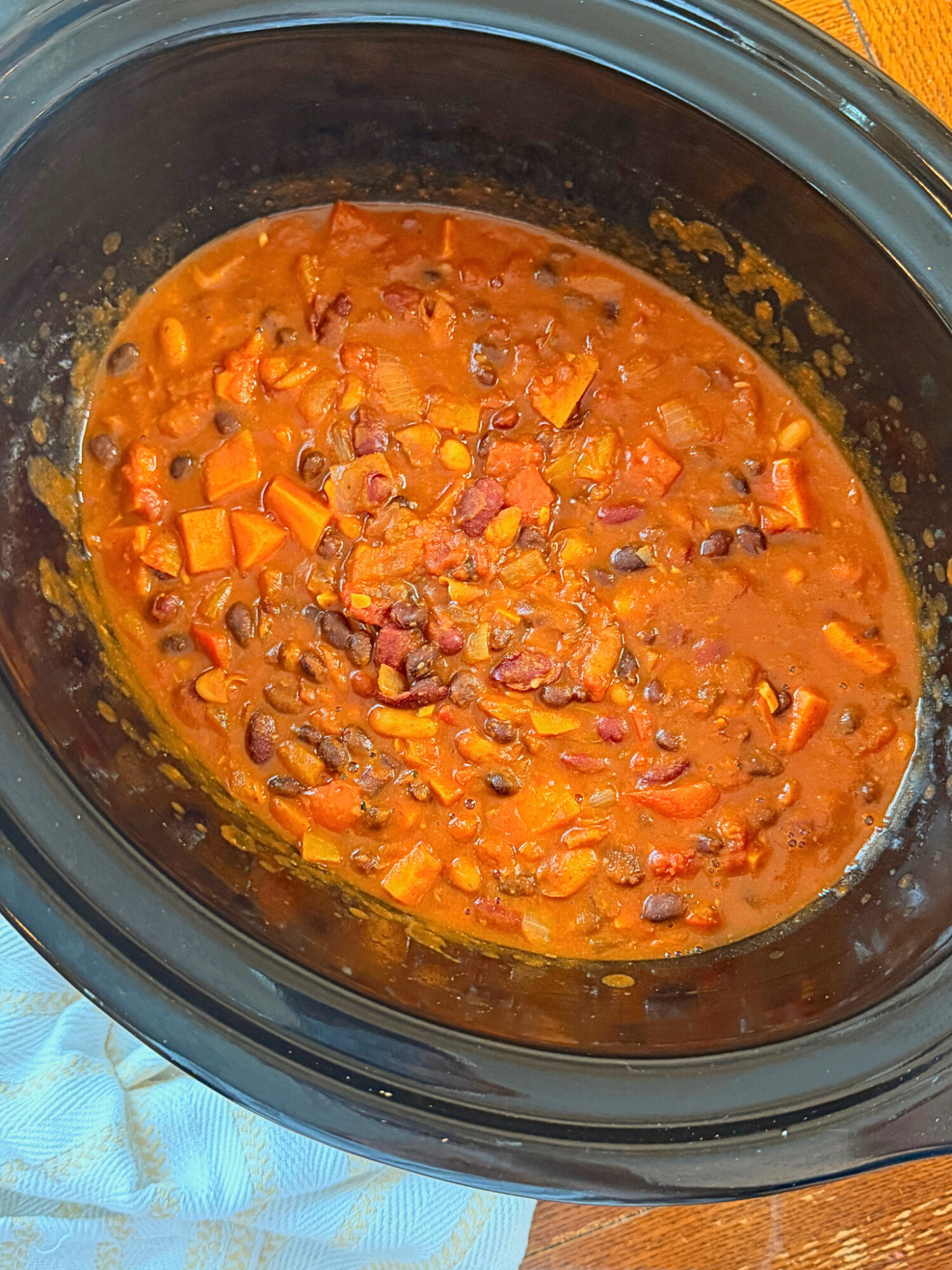 A slow cooker full of cooked chili.