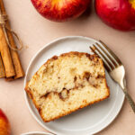 A slice of apple cinnamon bread surrounded by ingredients.