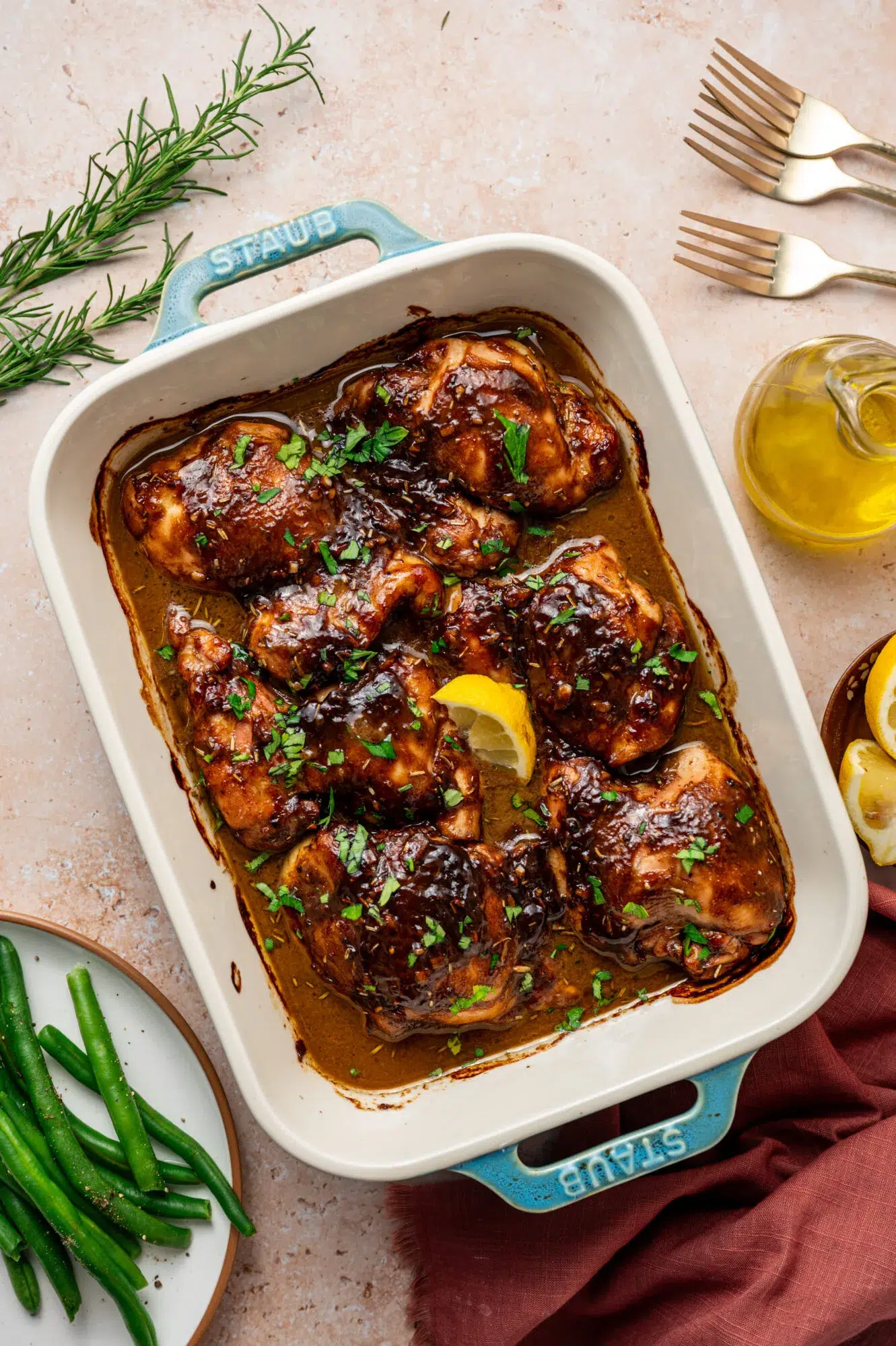 Balsamic Dijon mustard chicken thighs in a baking dish surrounded by ingredients.